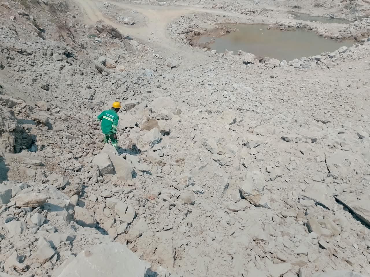 Worker conducting a post-blast bench inspection